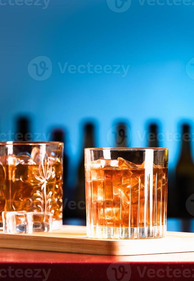 Vasos de whisky con hielo en un bar salón. foto