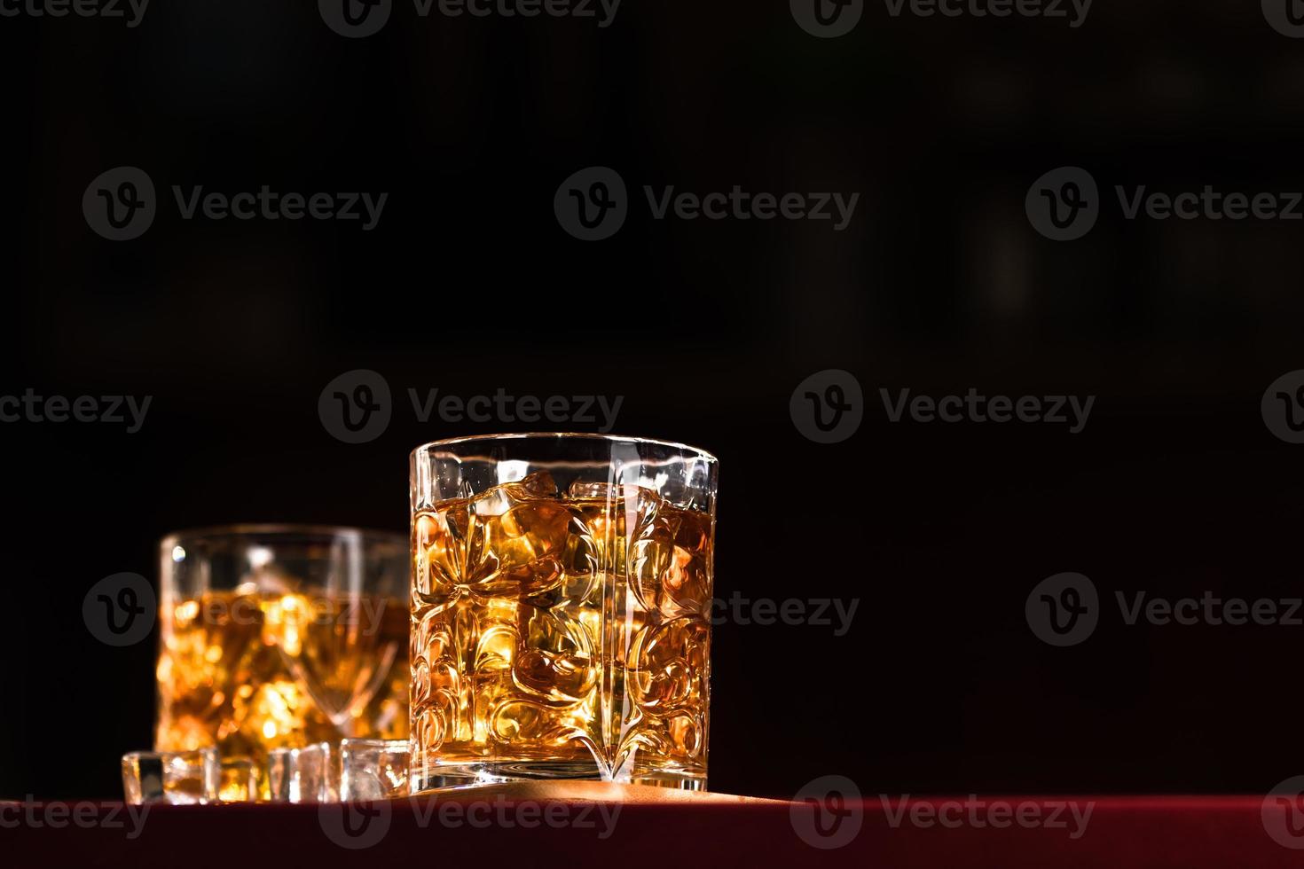 Vasos de whisky con hielo en un bar salón. foto