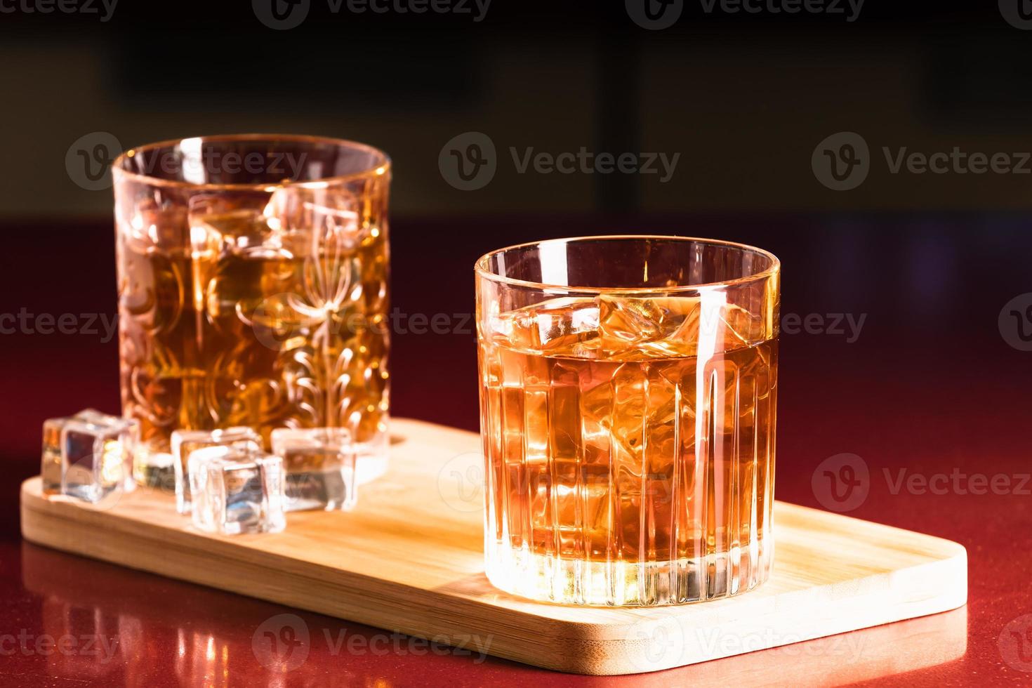 Vasos de whisky con hielo en un bar salón. foto