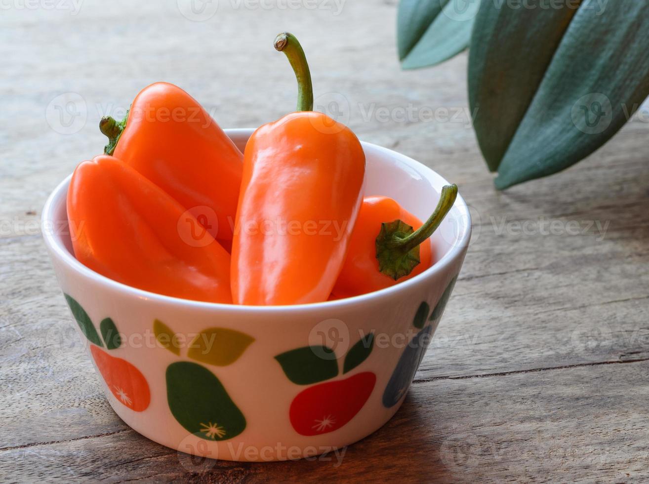 Orange paprika's in a colorfull bowl photo