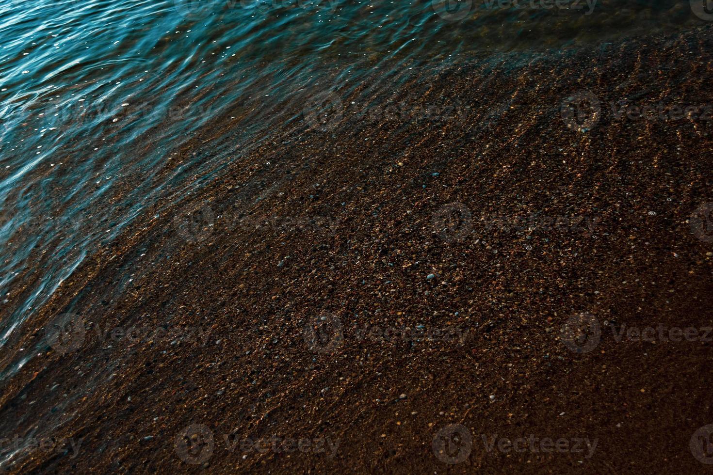 Seashore of sand and shells covered with salt water. photo