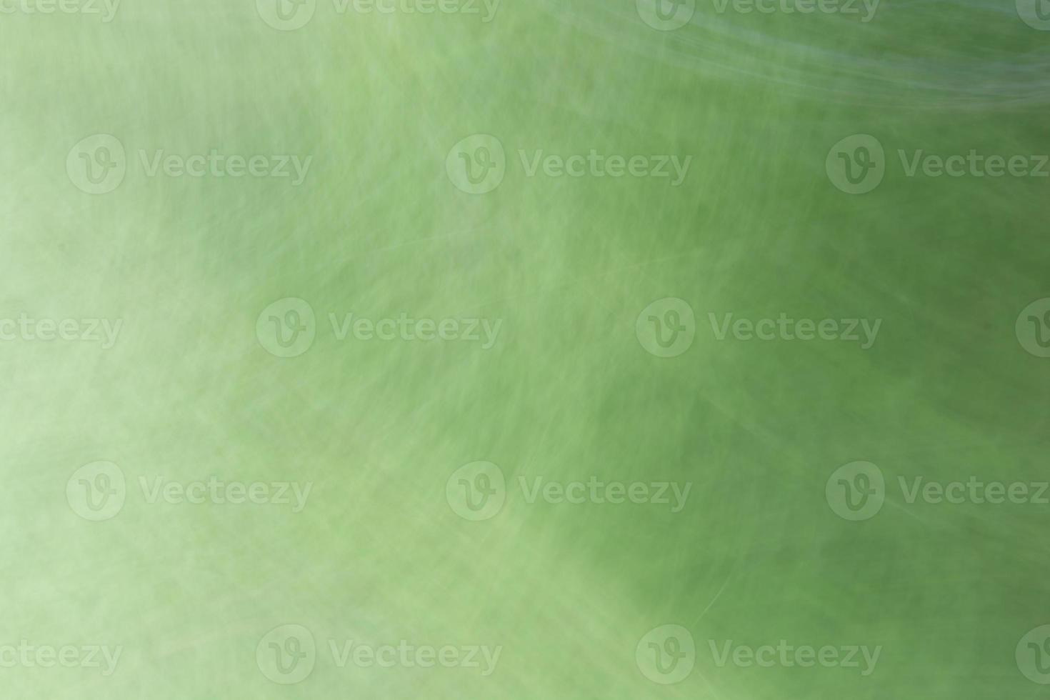 A gradient from a light green background with circular highlights, spots and scratches. photo