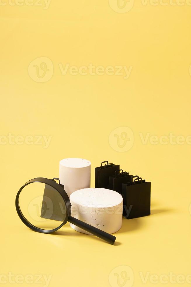 Empty mock podium or pedestal and black shopping bags in black friday sale on yellow background photo