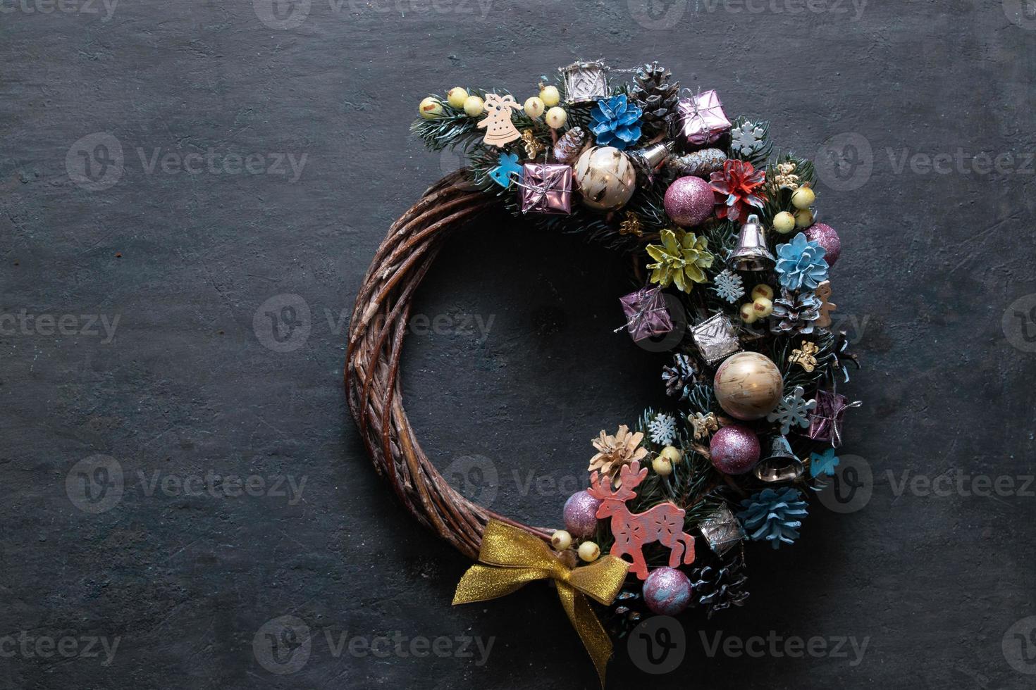 corona de navidad con decoración de colores sobre fondo negro foto