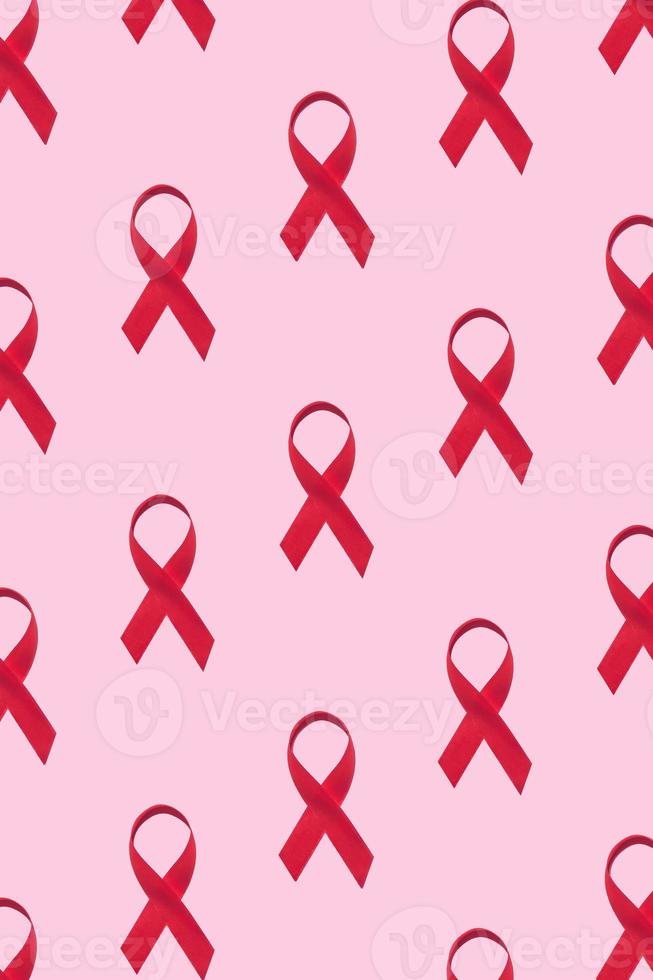 Red ribbons pattern symbol of world aids day on pink background photo