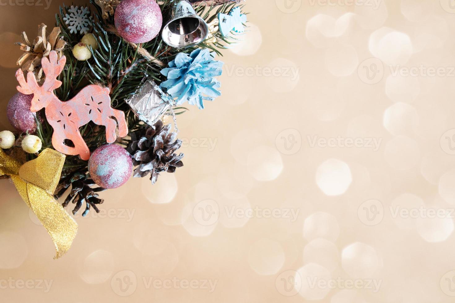 Fragment of a Christmas wreath with colored decor on a beige background with copy space photo