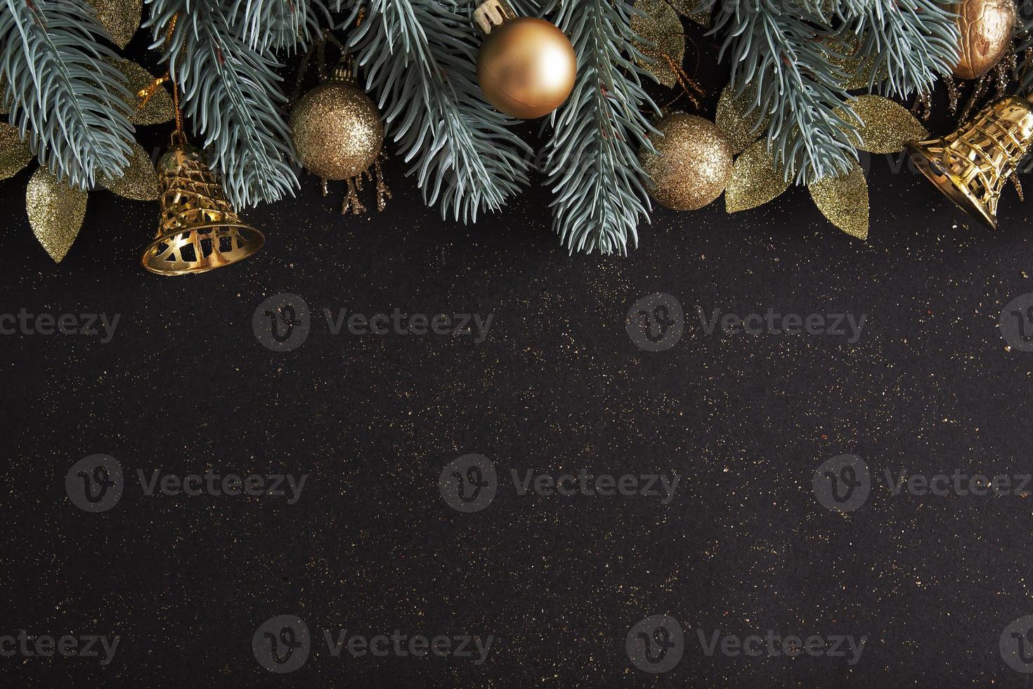 Diseño navideño con árboles de Navidad, adornos de oro y campanas sobre fondo negro foto
