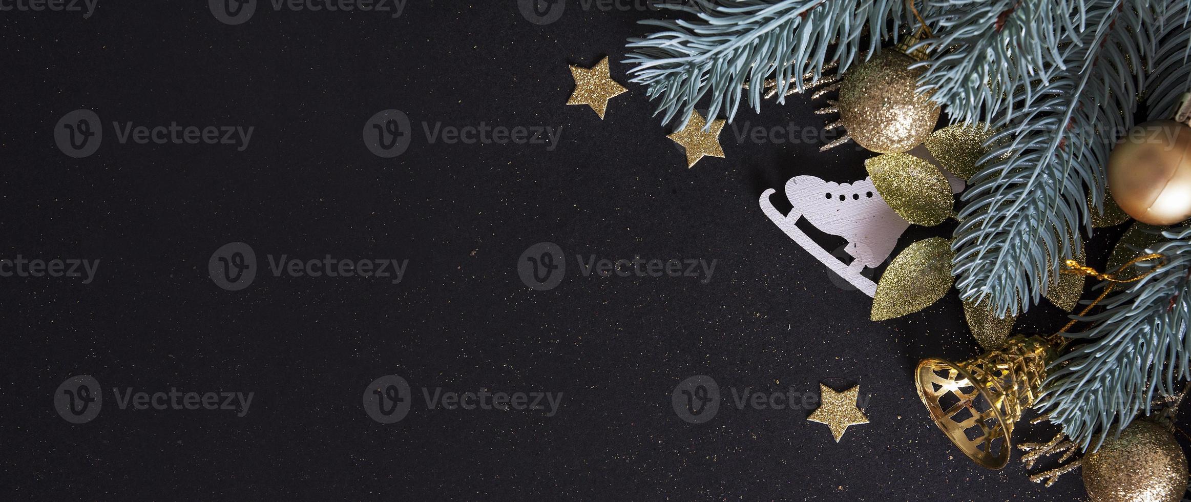 New Year banner decorated with tree branches, golden stars, bells on black background photo