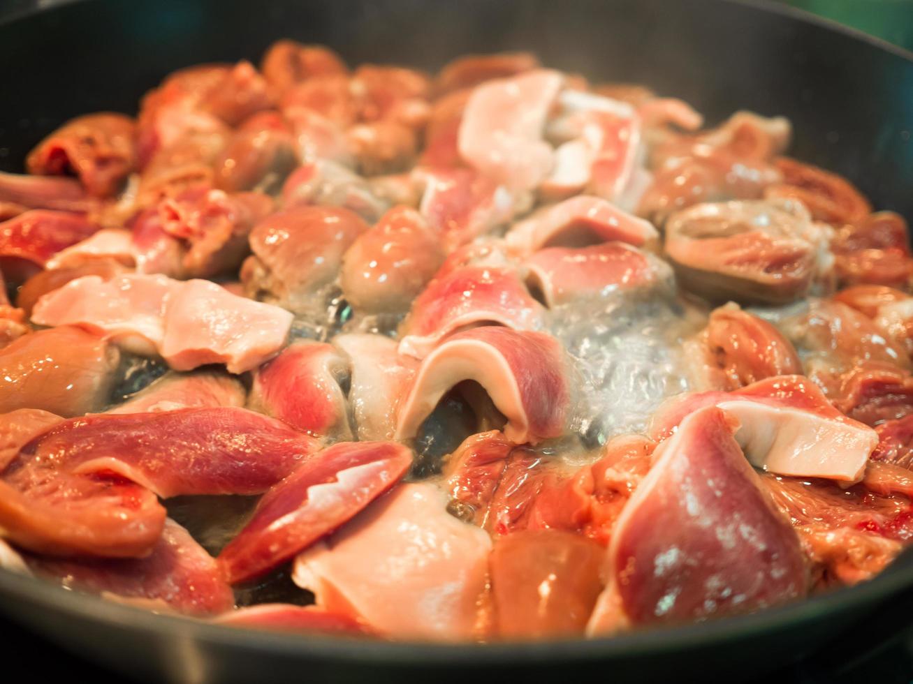 Asian food cooked chicken hearts fried in pan. photo