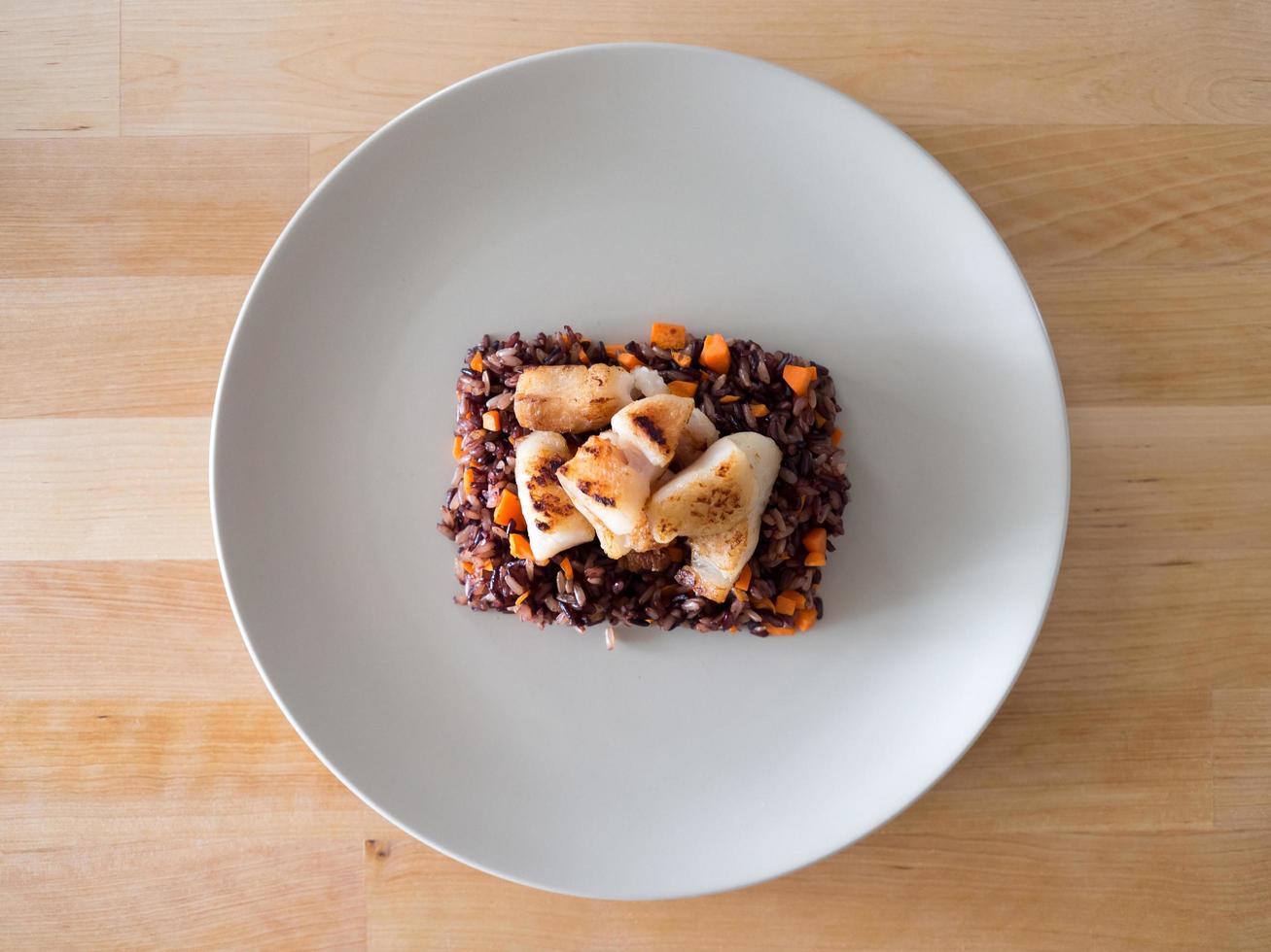 comida dietética de Riceberry con zanahorias y pescado. foto