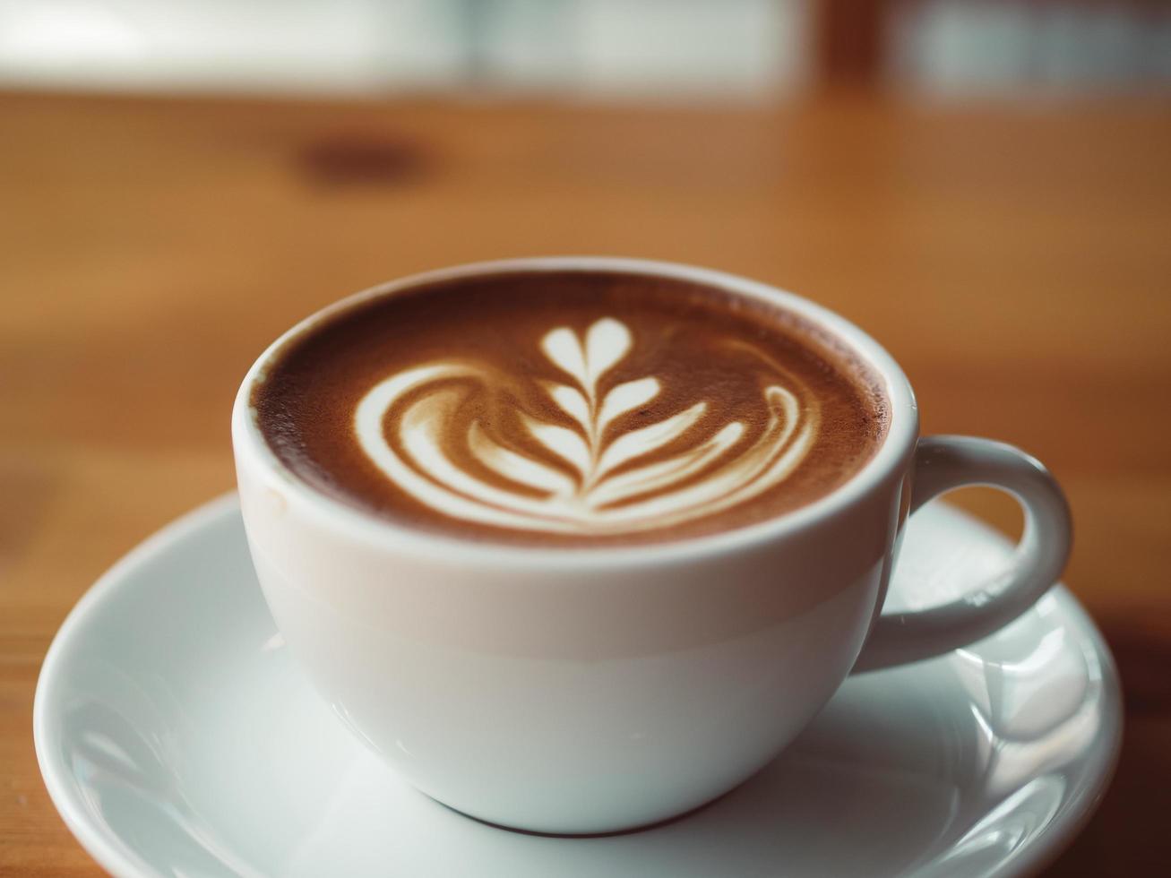 Cup of hot coffee served on wooden table in the cafe. photo