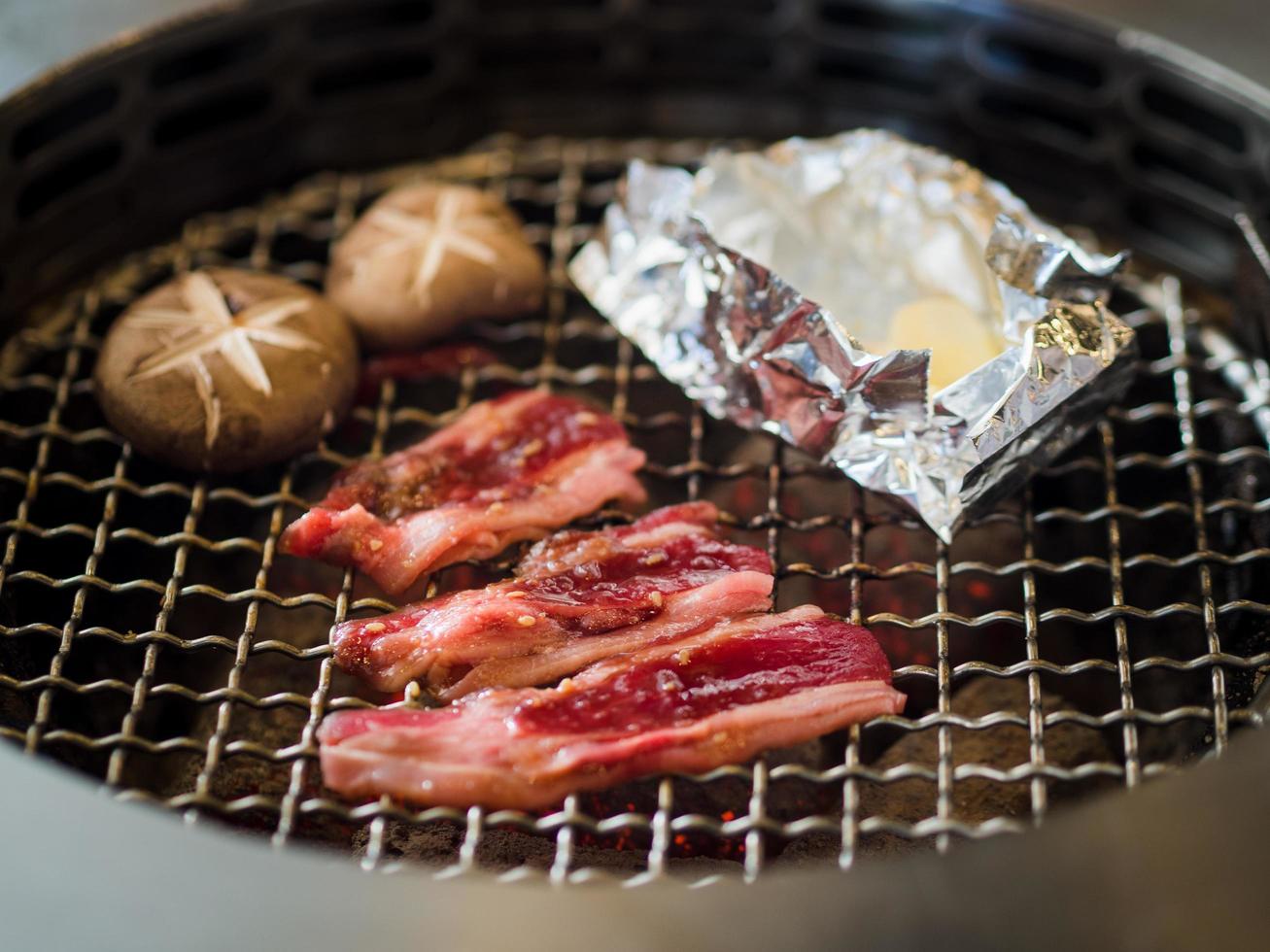 Grilling slices of beef with mushrooms and garlics. photo