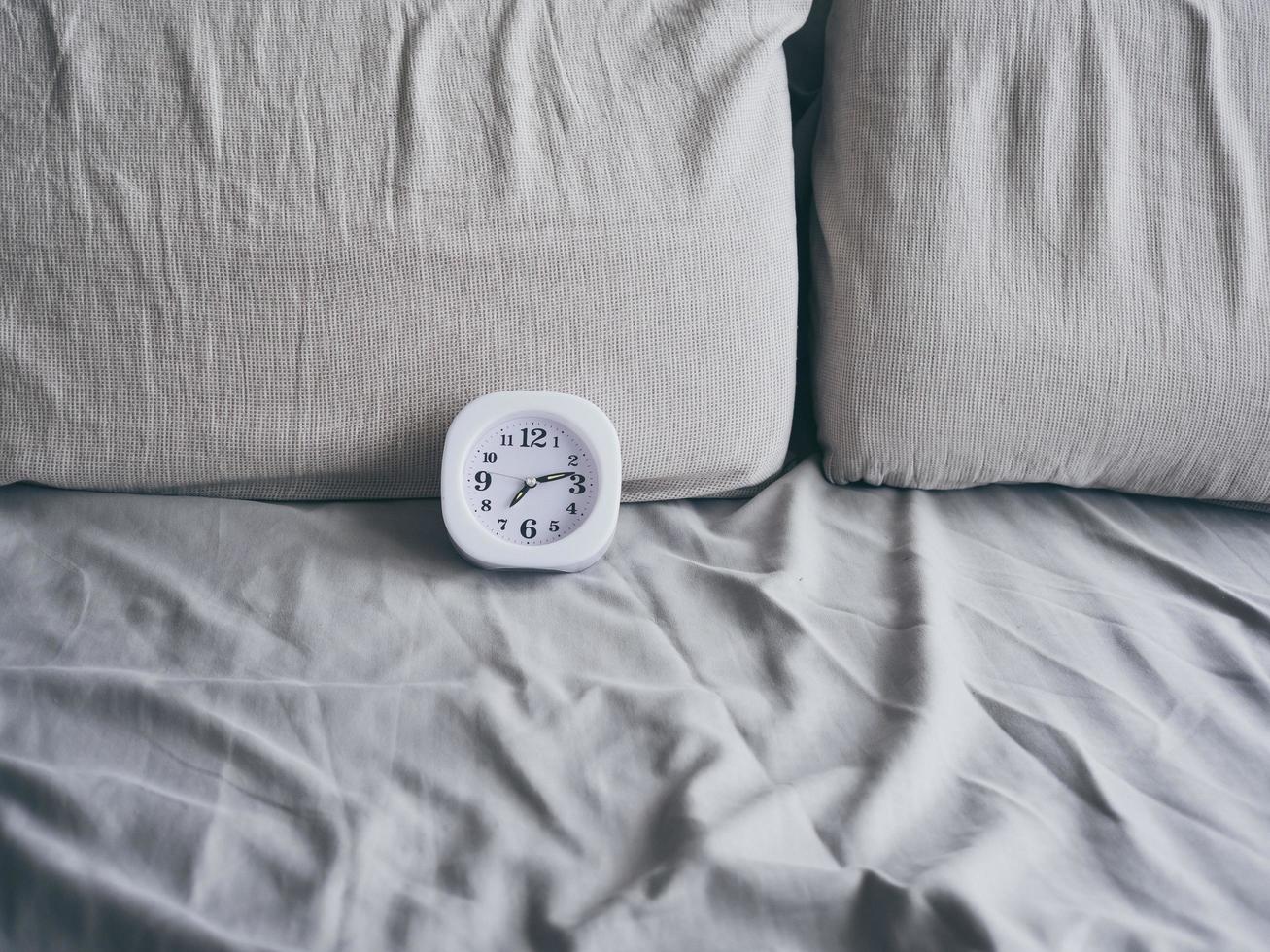 Clock on bed in the morning. photo