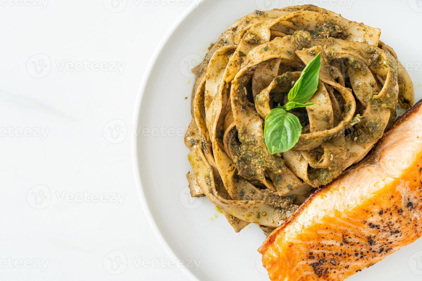 pesto fettuccine spaghetti pasta with grilled salmon fillet photo