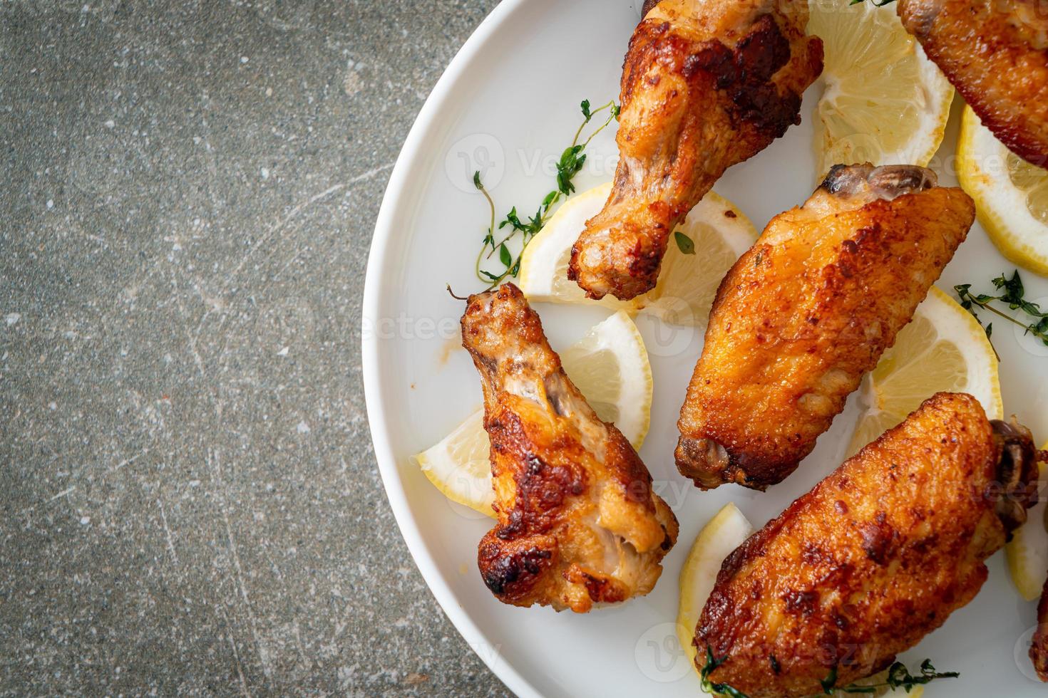 alitas de pollo fritas con limón y pimienta foto