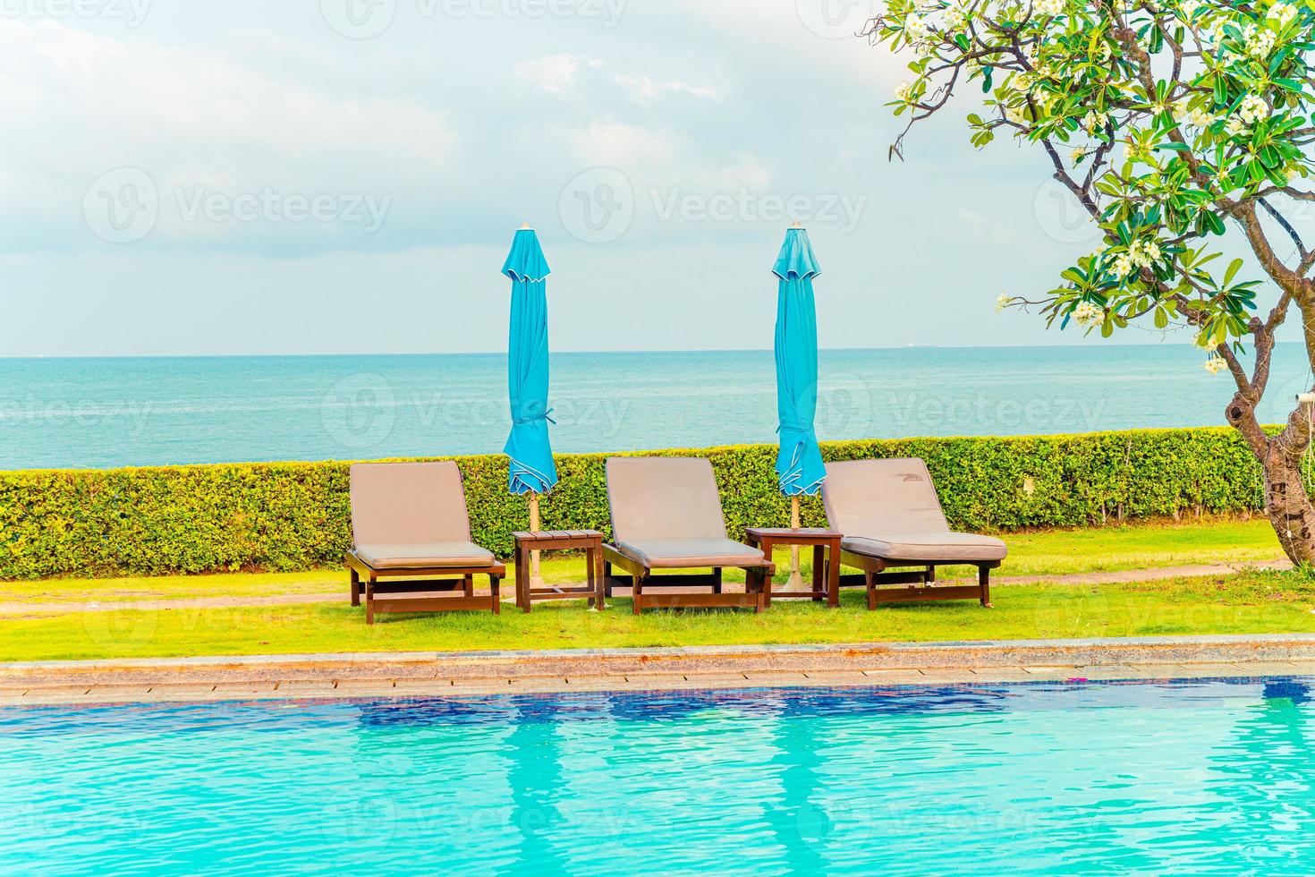 chair pool and umbrella around swimming pool photo