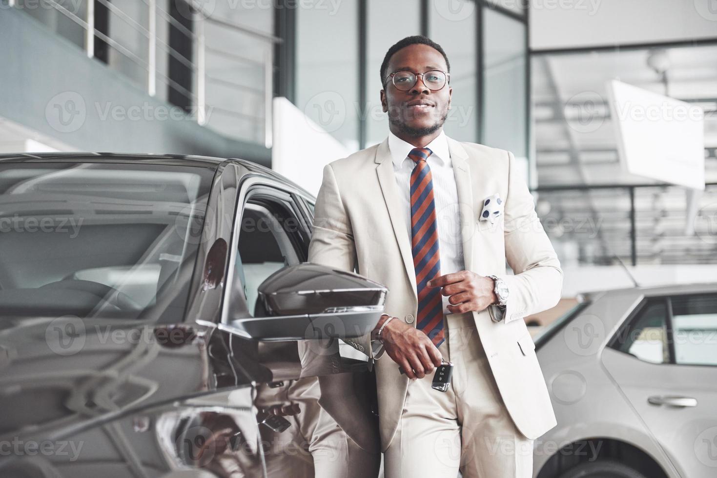 el joven atractivo empresario negro compra un coche nuevo, los sueños se hacen realidad foto