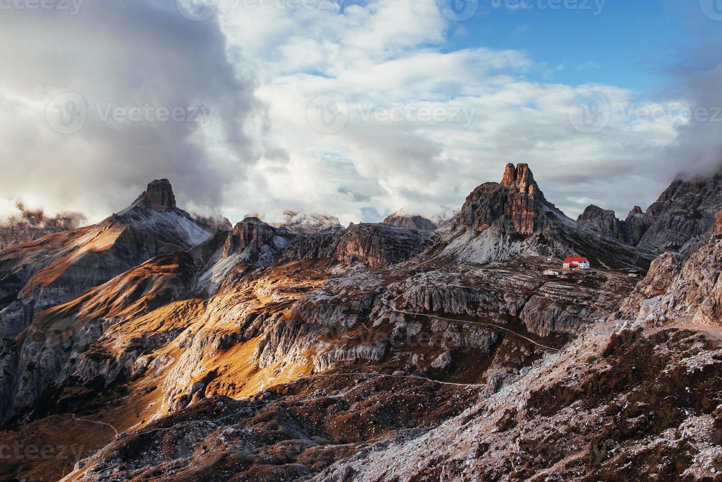 colina de las montañas dolomitas cerca del auronzo di cadore con pequeños edificios cerca del borde foto