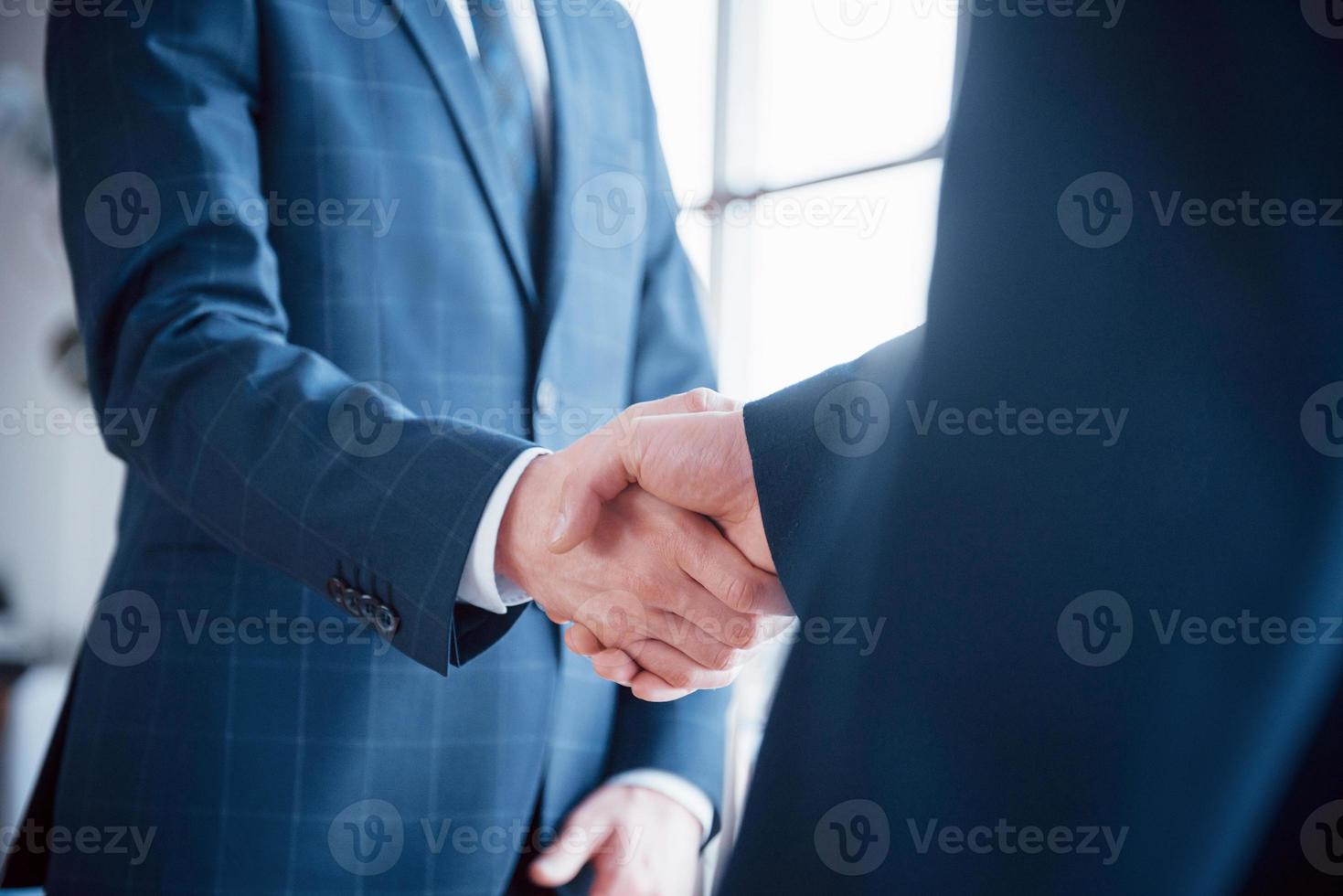 Dos hombre de negocios confiado un apretón de manos durante una reunión en la oficina, el saludo y el concepto de socio foto