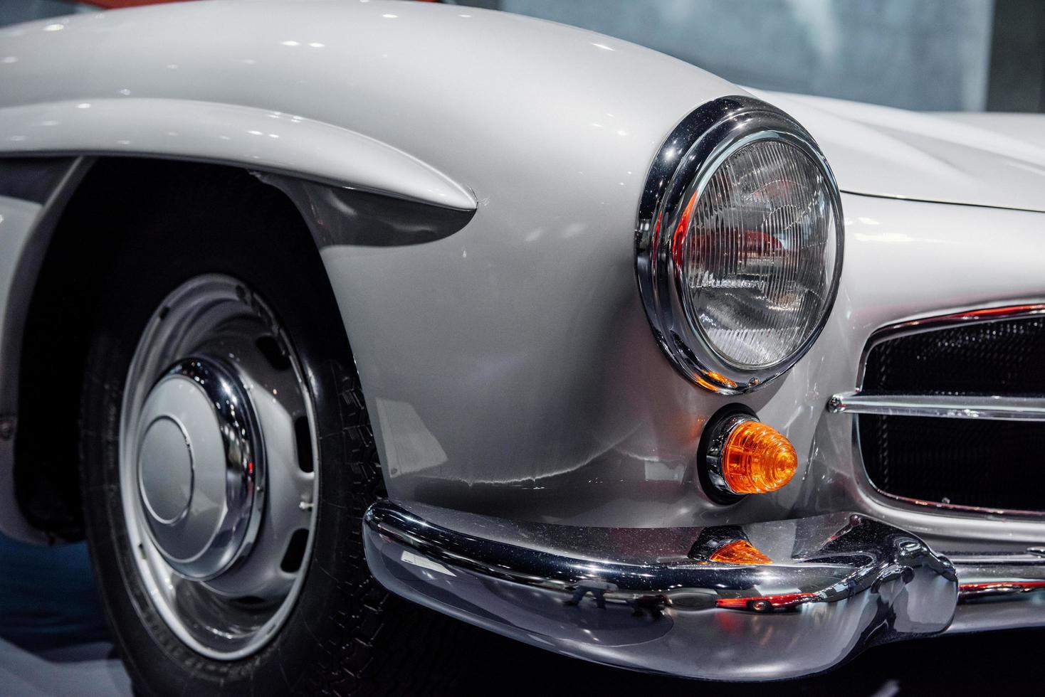 Shiny metal. Red vintage automobile on a car show. Close up view on headlights photo