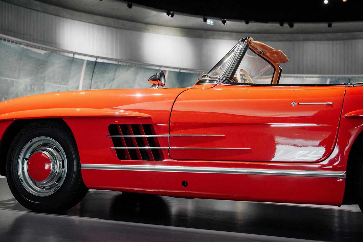 Vintage red polished car standing indoor. Photo from the side