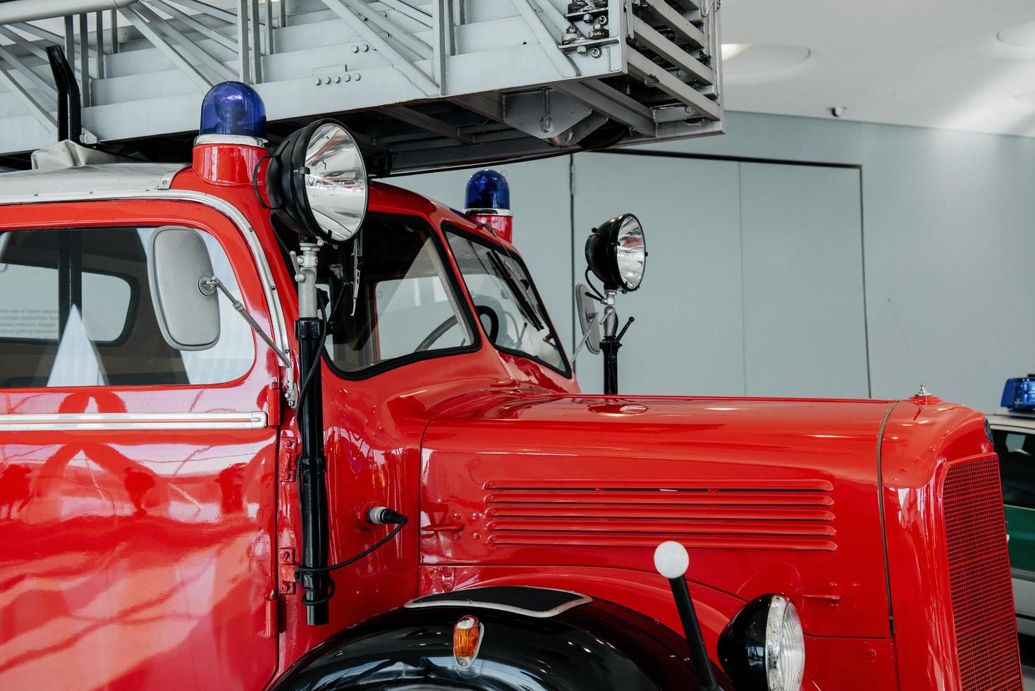 Side view. Front of the red polished fire truck standing indoor at exhibition photo