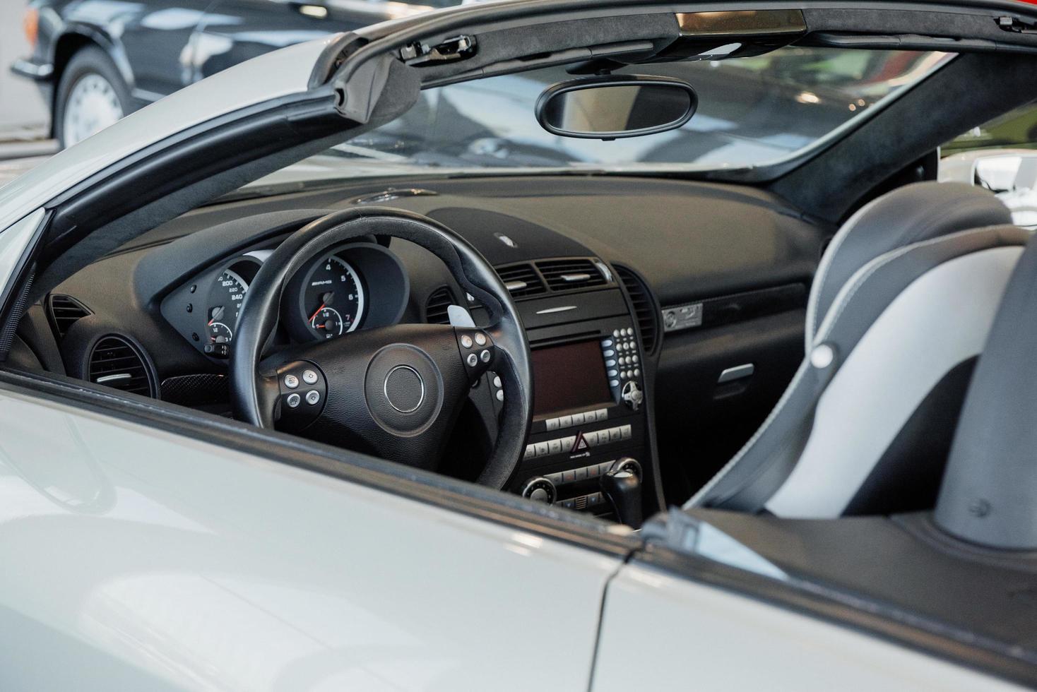 Mirando dentro de un moderno coche blanco pulido y elegante aparcado en el interior foto