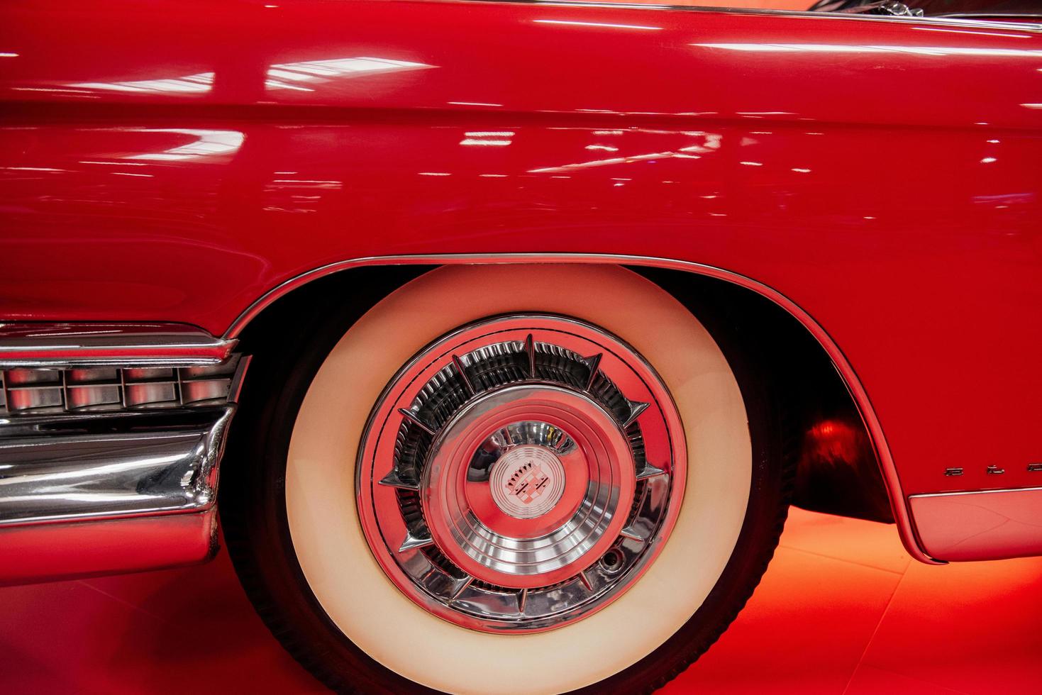 SINSHEIM, GERMANY - OCTOBER 16, 2018 Technik Museum. Left creamy colored wheel of red polished vintage automobile on car exhibition photo