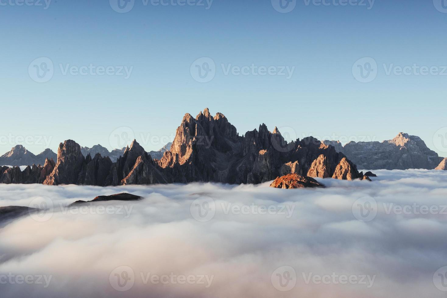 Mountains near Auronzo di Cadore filling with the hard mist in the daylight photo