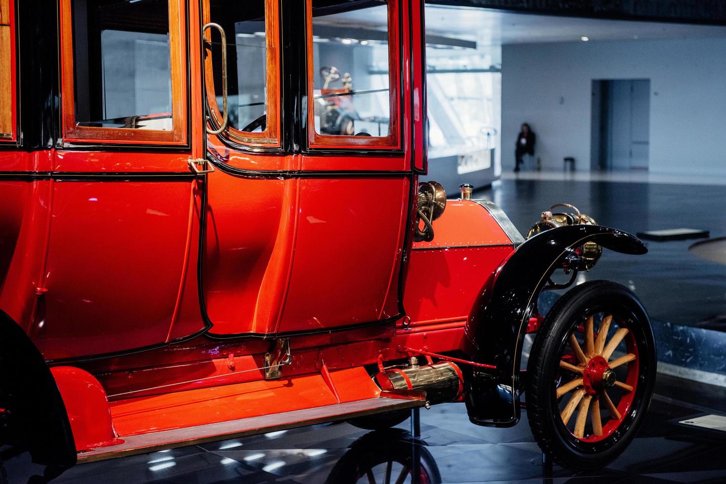 Side view of the red retro vintage car standing on the blue floor indoor photo