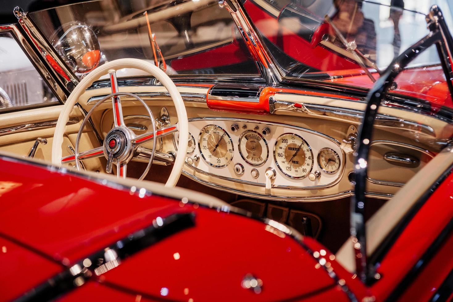 Red vintage automobile. Car dashboard, steering wheel, and front glasses captured from the back photo