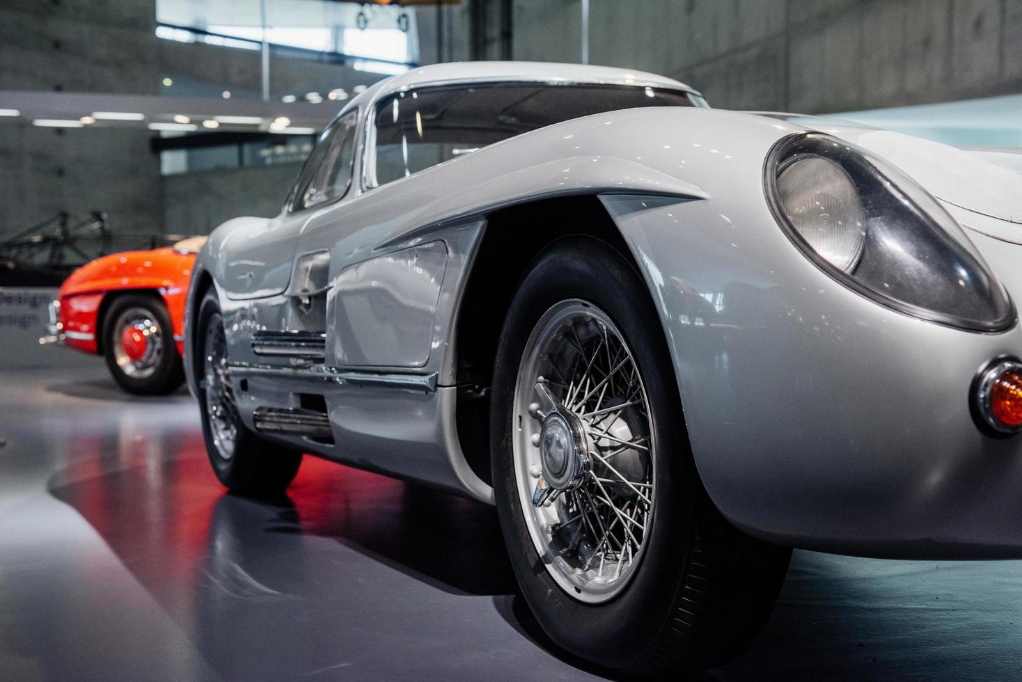 hermosas ruedas y frente. Lado derecho del gran vehículo retro blanco de pie en el interior en el salón del automóvil foto