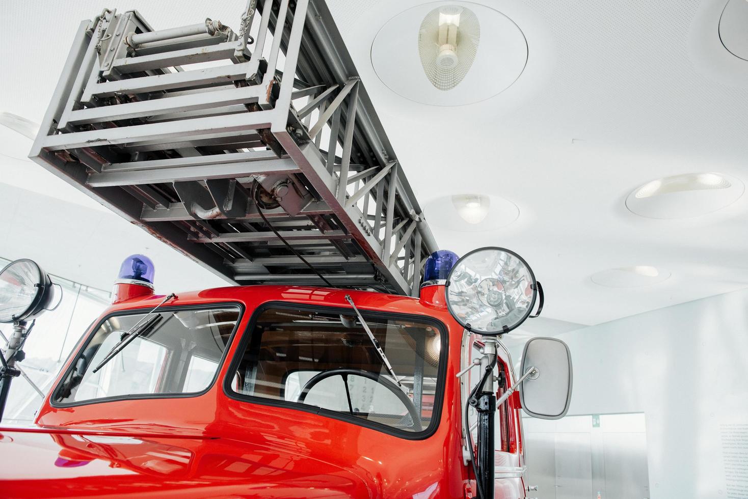 Frente al camión de bomberos rojo pulido de pie en el interior de la exposición foto