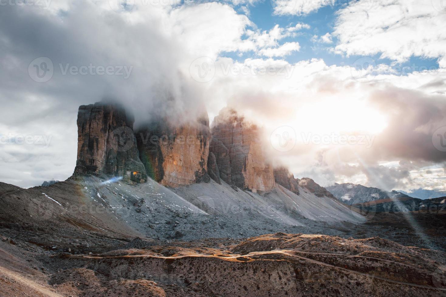 Beautiful sunlight creates colorful landscape. Mountains in the fog and clouds. Tre Cime di Lavaredo photo