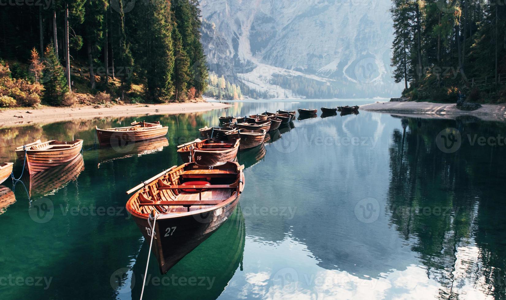 vista frontal. Los barcos conectados están en el agua clara cerca del bosque y la hermosa montaña majestuosa. foto