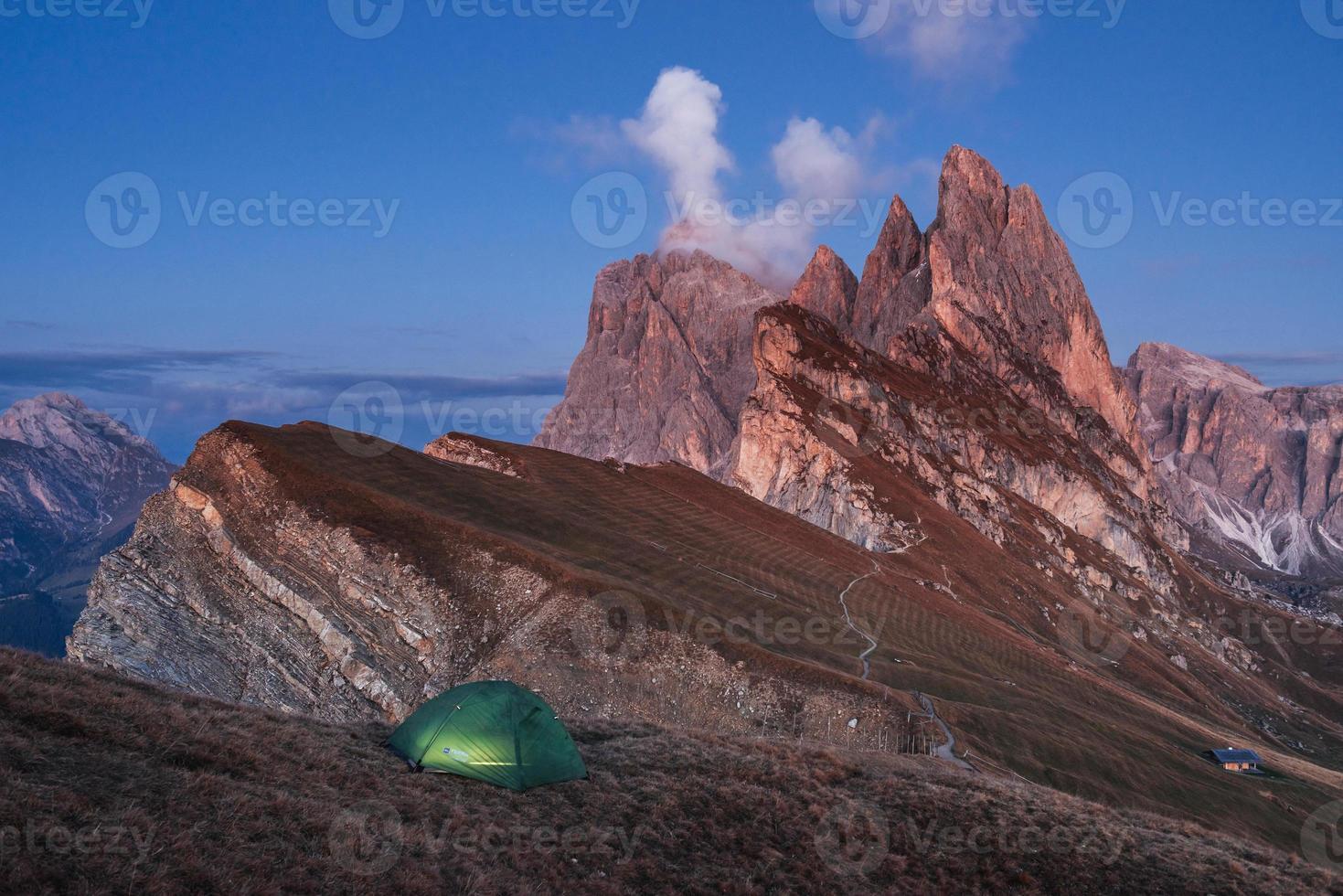 Evening and fog. Green tent standing on the hill. Awesome place in the alpes of Seceda photo