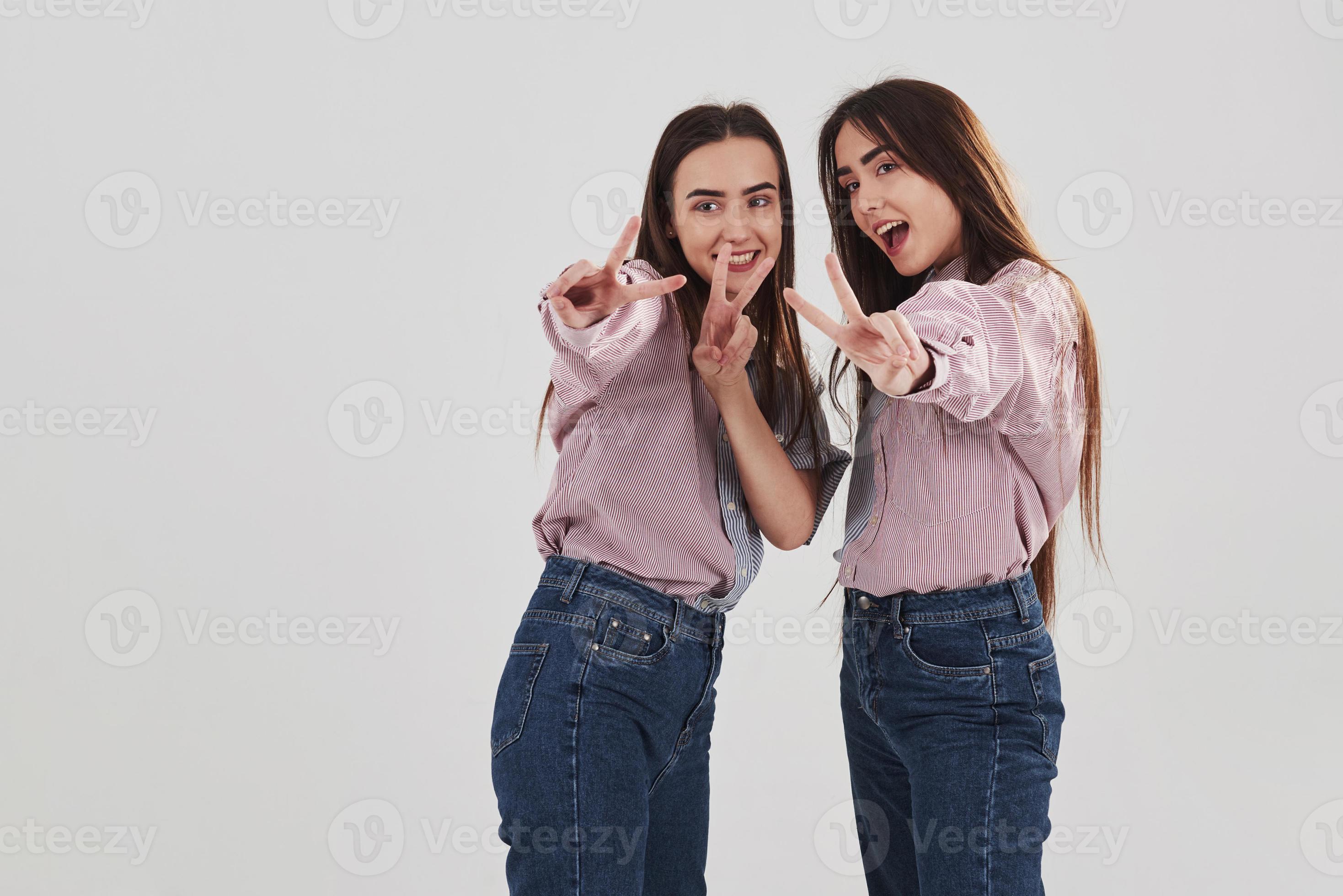 Image of Two girls standing funny poses - Austockphoto