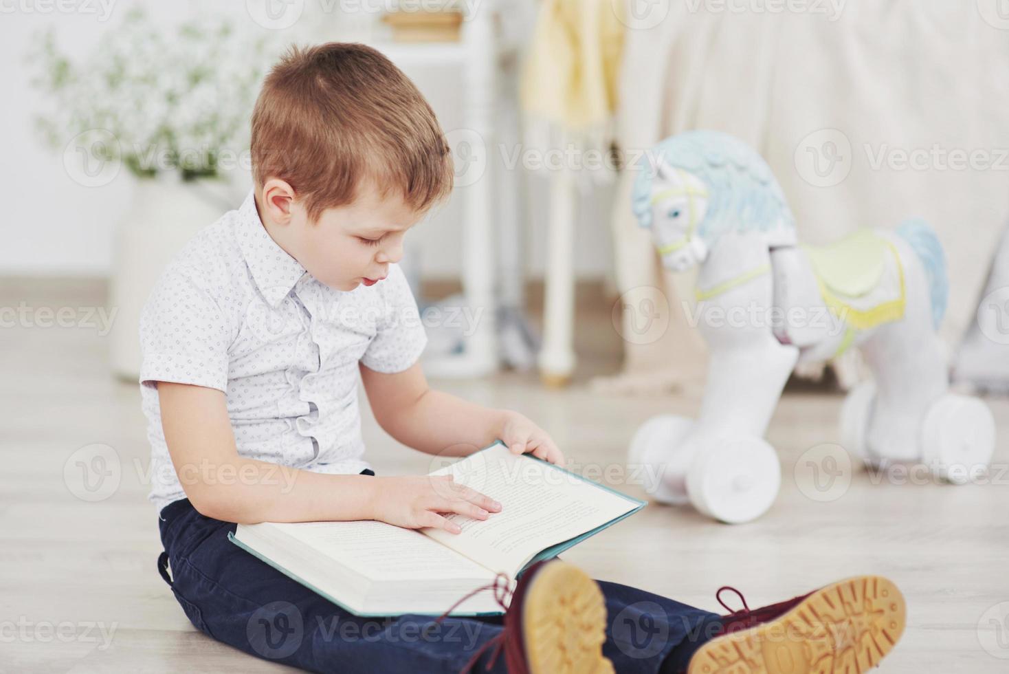 niño lindo va a la escuela por primera vez. niño con bolso y libro. niño hace un maletín, habitación infantil sobre un fondo foto