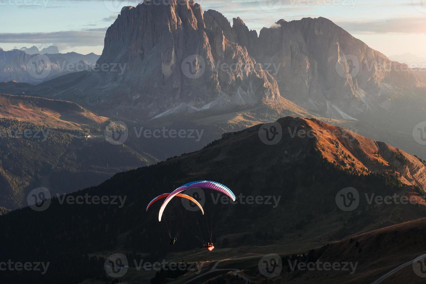 los dolomitas seceda y dos parapentes en las luces del atardecer foto