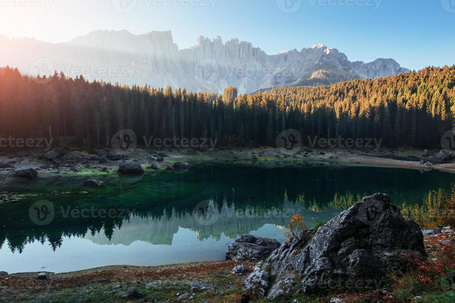 el amanecer está en camino. paisaje otoñal con lago claro, bosque de abetos y montañas majestuosas foto