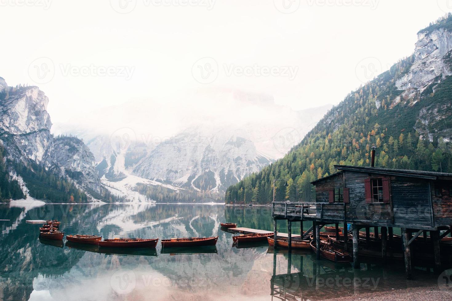 muchos de los barcos en el agua. buen paisaje con montañas. lugar turístico con edificio de madera y pera. foto