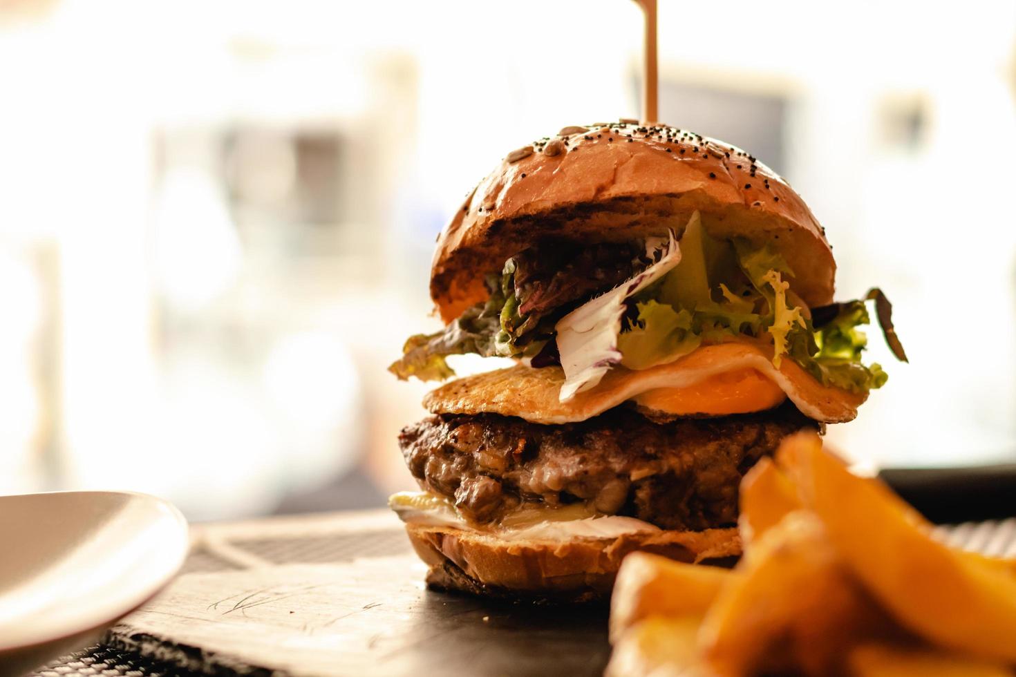 Hamburguesa con huevo y papas fritas servida en restaurante. foto