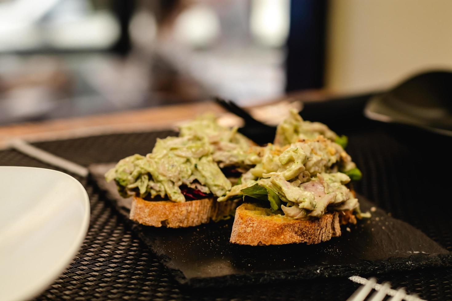 cocina fusión servida en un restaurante, pincho español con ensalada, salsa curry y pollo foto