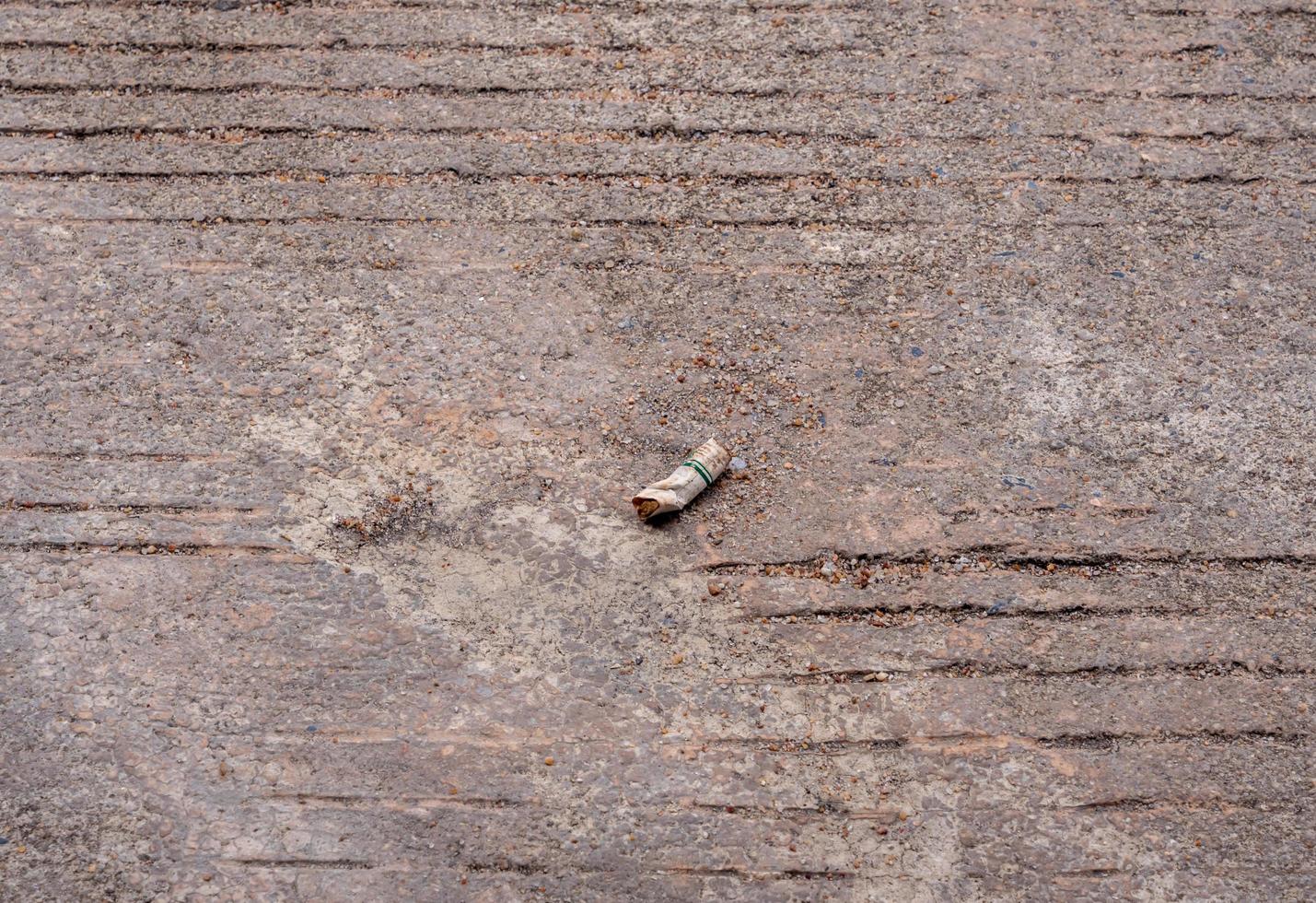 The cigarette butt let down on the concrete floor photo