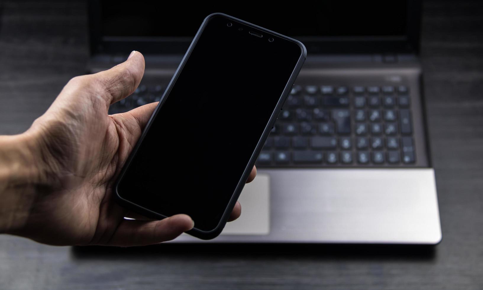 hand of senior person using a modern mobile in a workspace photo