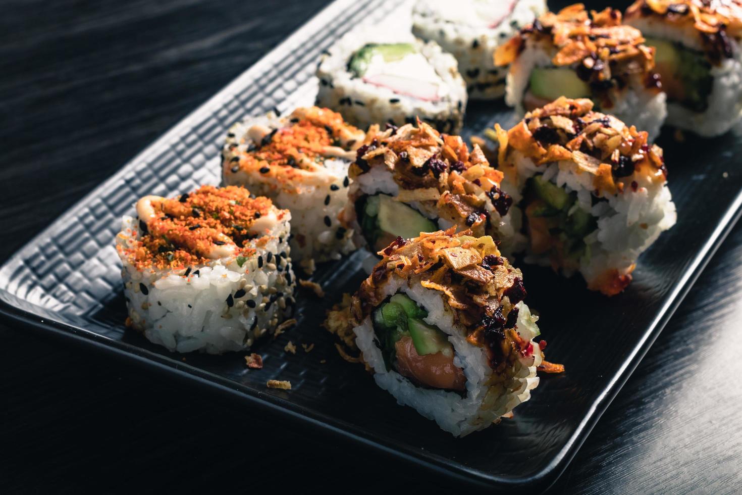 close up of sushi rolls on black tray photo