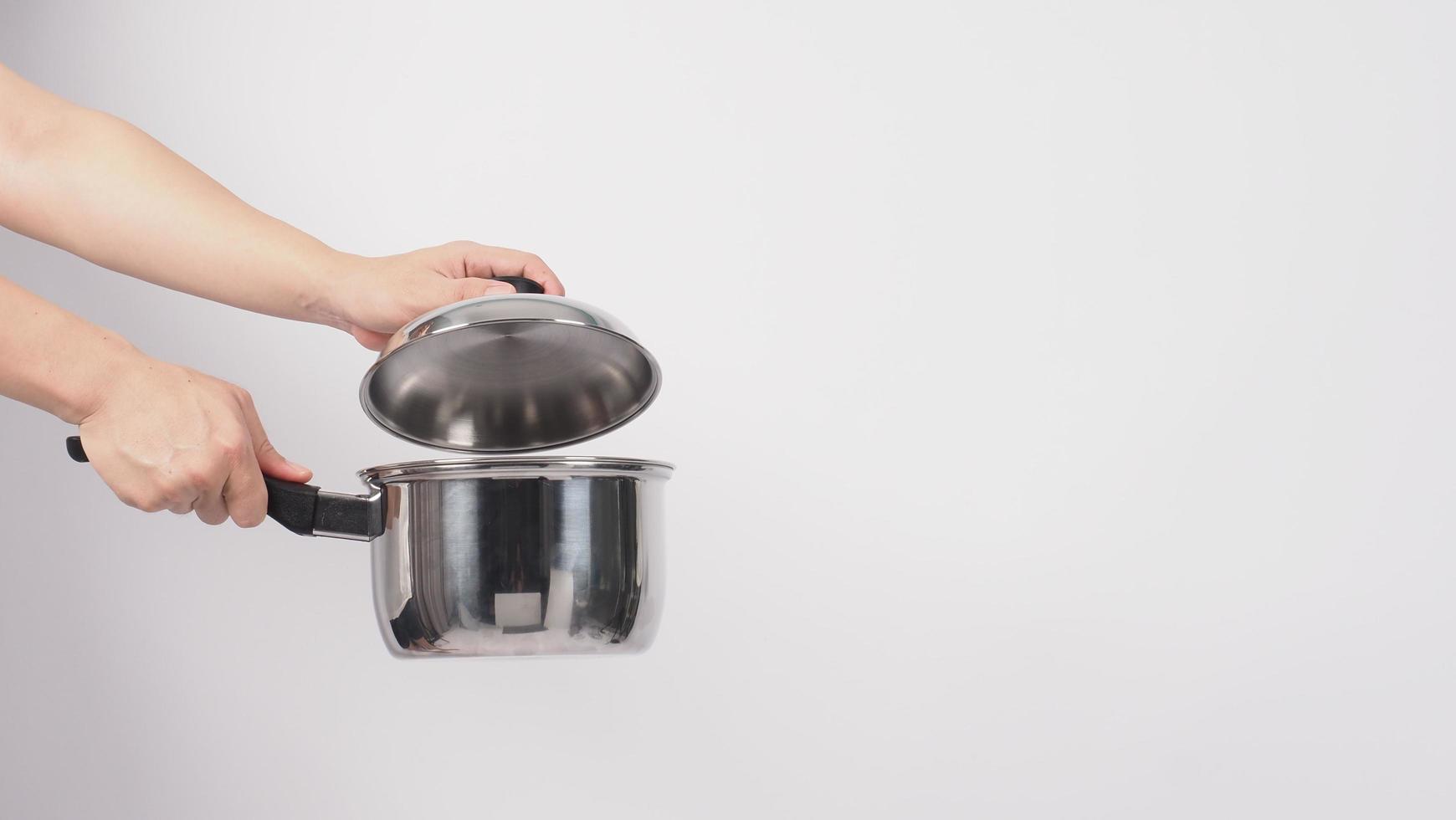 Pot cleaning. Man hand on white background cleaning the non stick pot photo