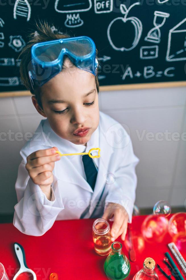 Kid doing soap bubbles against of drawn blackboard photo