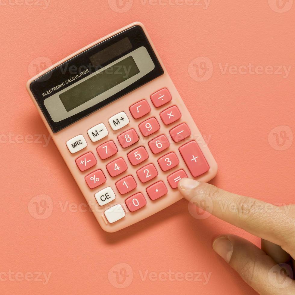 mano con calculadora rosa de color foto