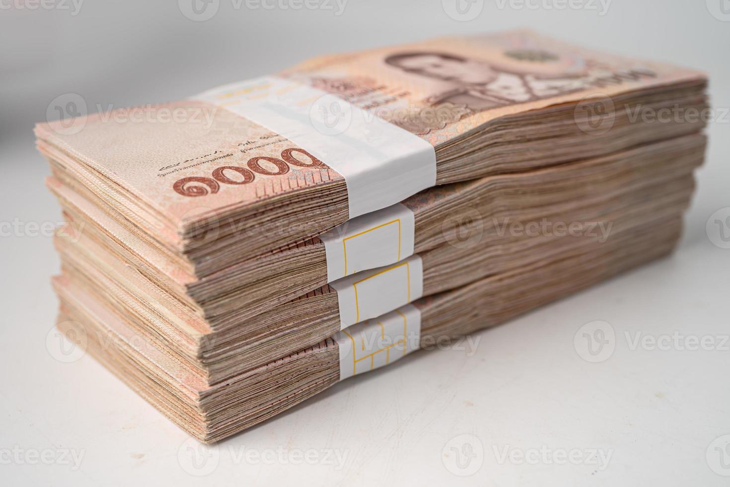 Stack of Thai baht banknotes on wooden background, business saving finance investment concept. photo